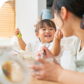 母親と食事する子供の写真